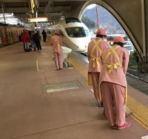 The cleaners bowing at the Shinkansen's arrival to the terminal station.