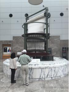 Ms. Narusawa and Mr. Yoshino at the cylindrical loom in the foyer of the Museum of Technology.