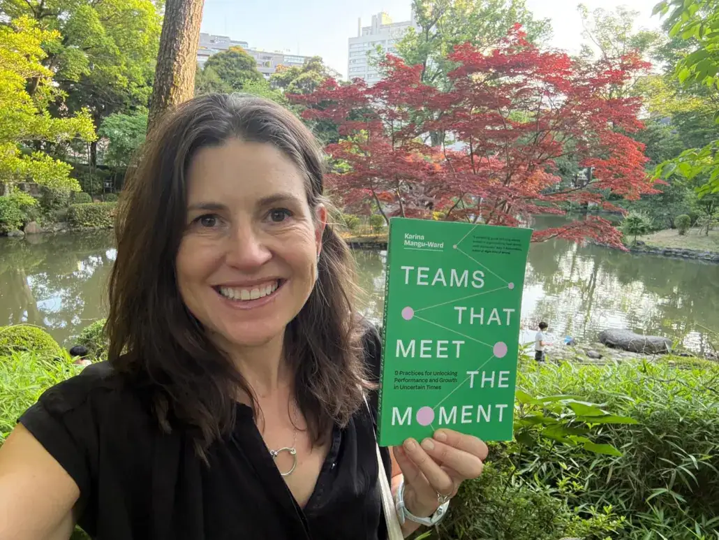 Katie Anderson holding the book "Teams that Meet the Moment" by Karina Mangu-Ward